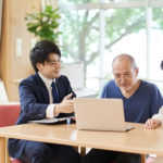 スタッフと入居者がパソコンを使って活動している様子
